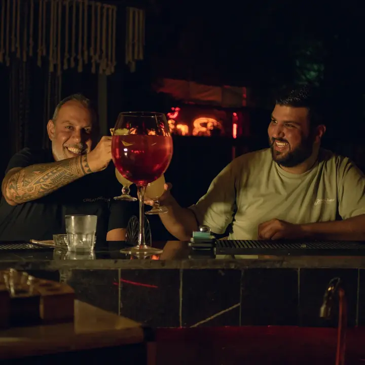 Two guests raising a glass of sangria at the bar