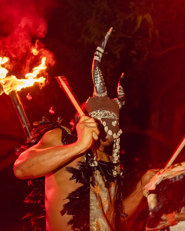 A masquerade drummer performing with fire at Brisa